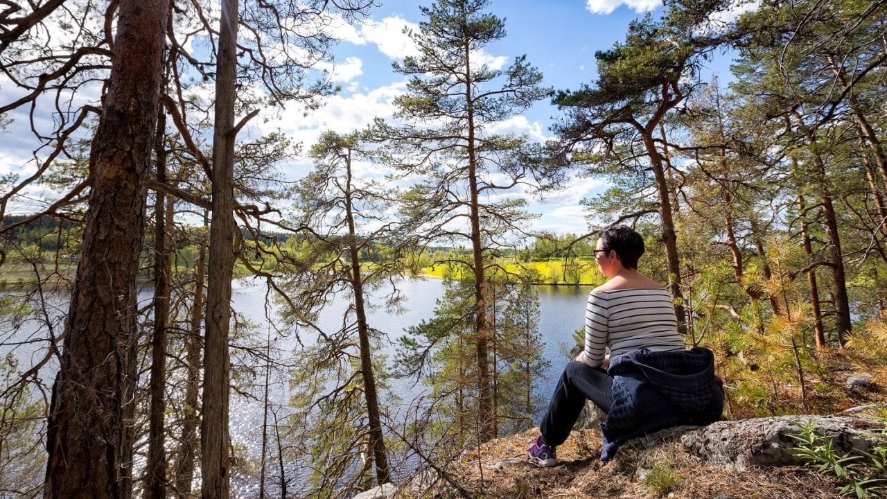 Nainen ihailee järvimaisemaa